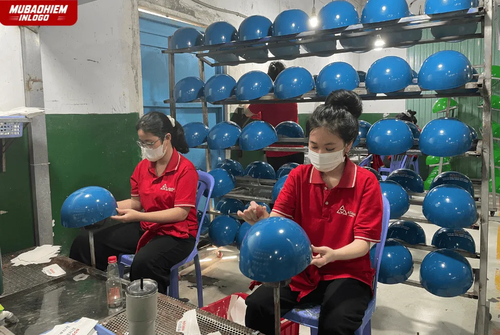 Công đoạn dán tem sản xuất nón bảo hiểm in logo phòng gym